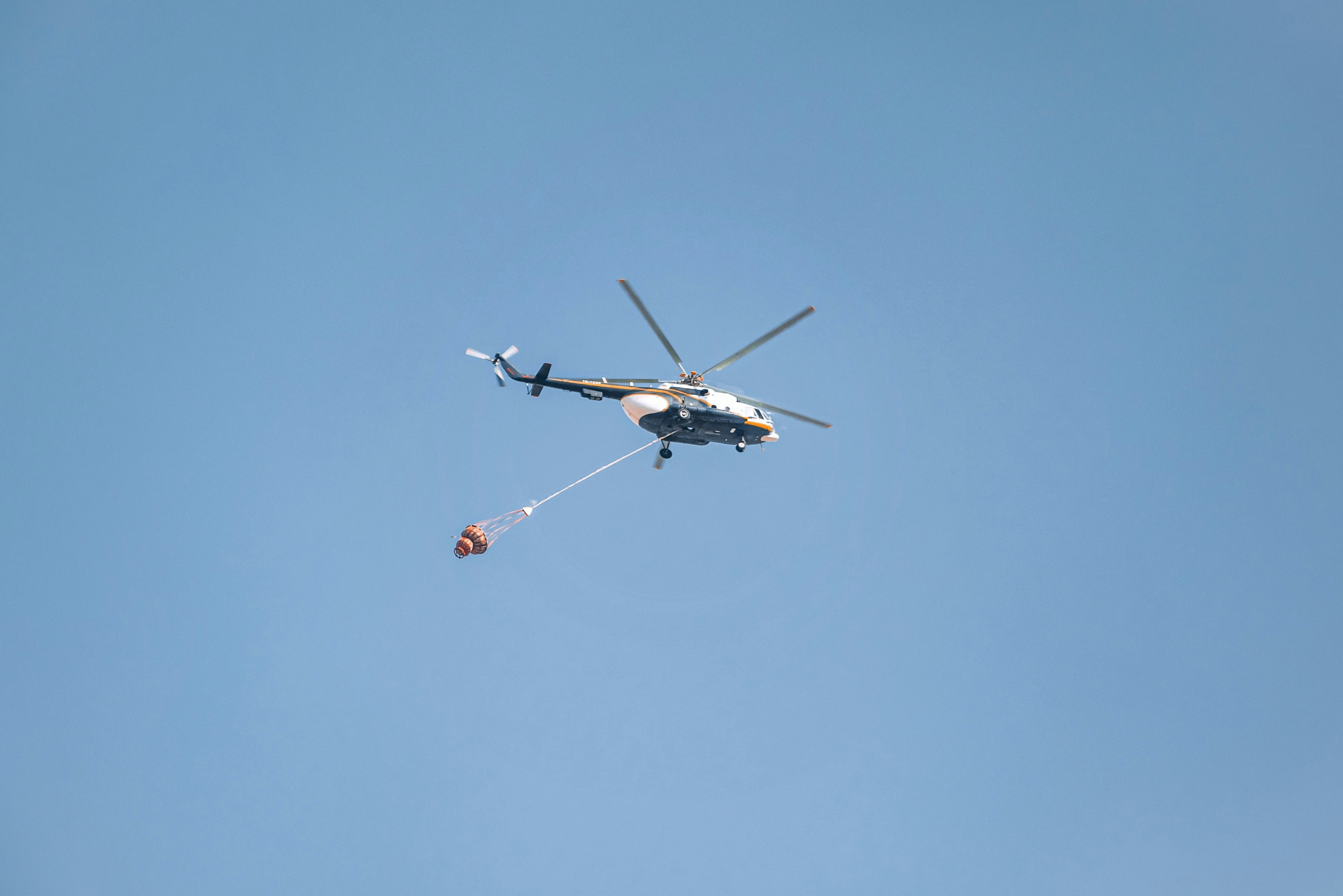 white and black helicopter in mid air